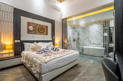 a bedroom with a bed and a shower and a tub at Villa Liamax by JB villas in Seminyak