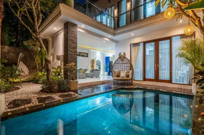 a swimming pool in a house with a bird cage at Villa Ashëla by JB Villas in Seminyak