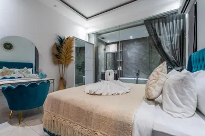 a bedroom with a large bed and a tub at Villa Ashëla by JB Villas in Seminyak