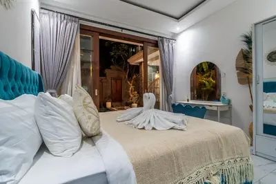 a bedroom with a large bed with white pillows at Villa Ashëla by JB Villas in Seminyak