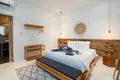 a bedroom with a large bed with white sheets at Vajrayana - 10 Min From The Beach, Serene Villa with Pool View in Kerobokan