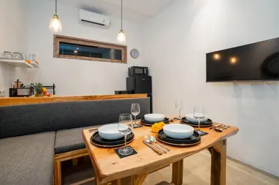a wooden table with plates and glasses on top of it at Vajrayana - 10 Min From The Beach, Serene Villa with Pool View in Kerobokan