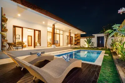 a villa with a swimming pool at night at Umanala - 5 Min To Beach, Sleek Villa with Spacious Pool Area in Kerobokan