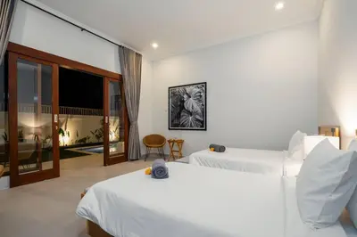 a hotel room with two beds and a balcony at Umanala - 5 Min To Beach, Sleek Villa with Spacious Pool Area in Kerobokan