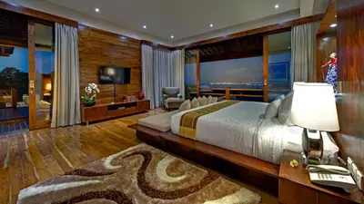a large bedroom with a large bed and a living room at Villa Aiko in Jimbaran