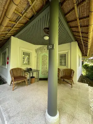 a patio with a table and chairs and a pole at Poppies Cottages on Two in Legian