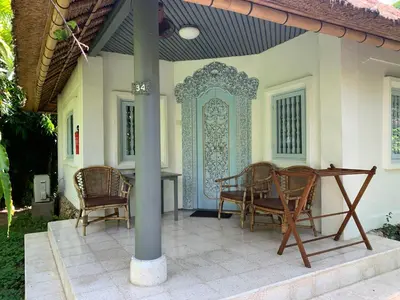 a patio with chairs and a table on a house at Poppies Cottages on Two in Legian