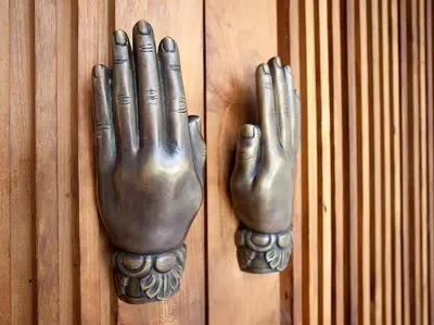 a pair of metal hands on a wooden door at Villa Adasa by Elite Havens in Seminyak