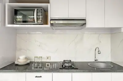 a white kitchen with a sink and a microwave at Villa De Luca By Aishwarya International in Umalas