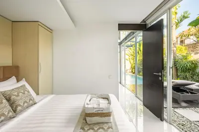 a bedroom with a bed with a door to a patio at Villa De Luca By Aishwarya International in Umalas