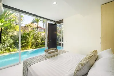 a bedroom with a bed and a swimming pool at Villa De Luca By Aishwarya International in Umalas