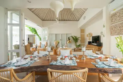 a dining room with a large wooden table and chairs at Casa Elias Seminyak in Seminyak