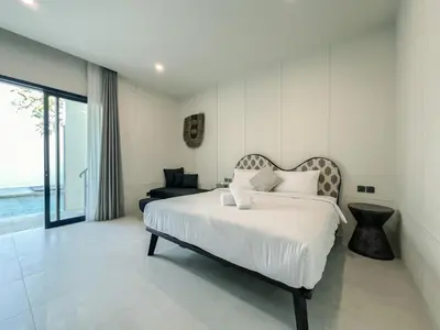 a bedroom with a large white bed and a window at Cara Villa Bali in Seminyak