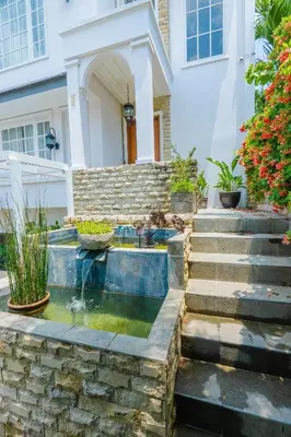 a house with a pond in the front yard at Viki Nest by SooBali 4BR in Umalas