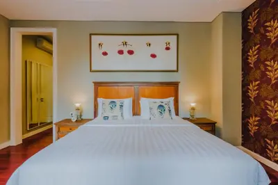 a bedroom with a large white bed with two pillows at Viki Nest by SooBali 4BR in Umalas