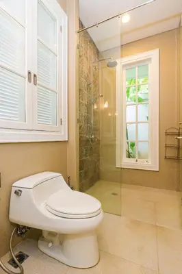 a bathroom with a toilet and a glass shower at Viki Nest by SooBali 4BR in Umalas