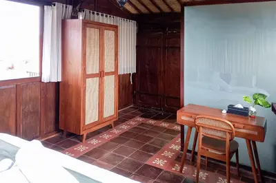 a bedroom with a desk and a bed and a tub at Wakajima House Kerobokan by The Lavana in Kerobokan