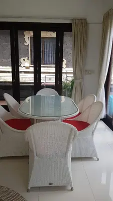 a glass table and chairs in a room at Kubu Nesa in Jimbaran