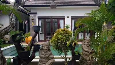 a house with some statues in front of a house at Kubu Nesa in Jimbaran