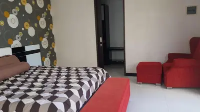 a bedroom with a bed and a red couch at Kubu Nesa in Jimbaran
