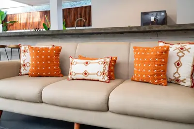 a couch with orange and white pillows on it at Beautiful modern villa in the heart of Seminyak in Seminyak