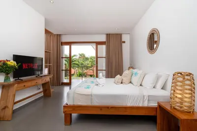 a bedroom with a white bed and a television at Beautiful modern villa in the heart of Seminyak in Seminyak