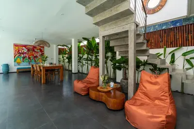 a living room with orange chairs and a table at Beautiful modern villa in the heart of Seminyak in Seminyak