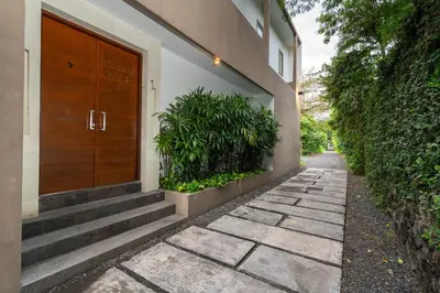 a house with a wooden door and a walkway at Beautiful modern villa in the heart of Seminyak in Seminyak