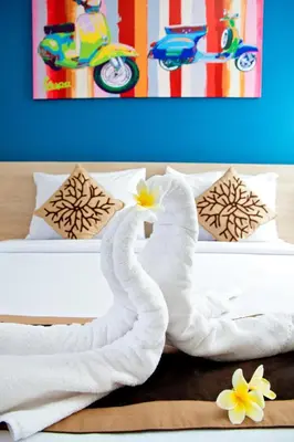a bed with white towels and flowers on it at The Salak Style Hotel in Denpasar