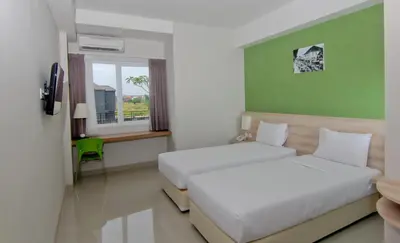 a hotel room with two beds and a window at The Salak Style Hotel in Denpasar