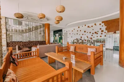 a restaurant with wooden benches and tables in it at The Salak Style Hotel in Denpasar