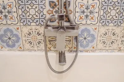 a shower in a bathroom with tiles on the wall at La Rylin Villa in Kuta