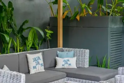 a gray couch with pillows on a patio with plants at Omkara 2 BR Deluxe Private Pool Villa ZN253 in Seminyak
