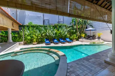 a swimming pool with blue chairs in a backyard at Onkita 4 BR Private Pool Villa ZN254 in Seminyak