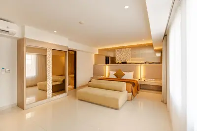 a bedroom with a bed and a couch at Kuta Angel Hotel in Kuta