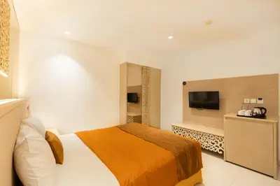 a hotel room with a bed and a flat screen tv at Kuta Angel Hotel in Kuta