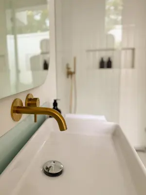 a bathroom sink with a gold faucet and a mirror at Arunika Prime Villa in Seminyak