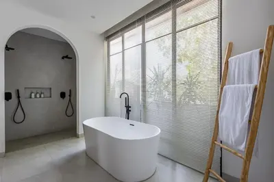 a bathroom with a white tub and a large window at Villa Harper by BaliSuperHost in Canggu