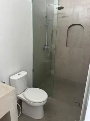 a bathroom with a toilet and a glass shower at Villa with pool Nusa Dua in Nusa Dua