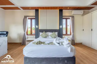 a bedroom with a large bed with white sheets at Villa Sila by Bukit Vista in Canggu