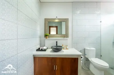 a bathroom with a sink and a toilet and a mirror at Villa Sila by Bukit Vista in Canggu