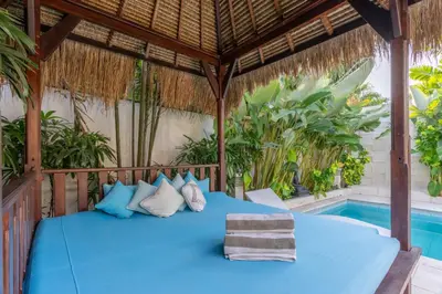 a bed in a pavilion next to a swimming pool at Villa Jasmin Seminyak in Seminyak
