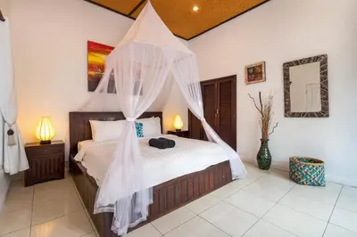 a bedroom with a bed with a mosquito net at Villa Jasmin Seminyak in Seminyak