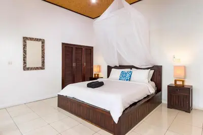 a bedroom with a large bed with white sheets at Villa Jasmin Seminyak in Seminyak