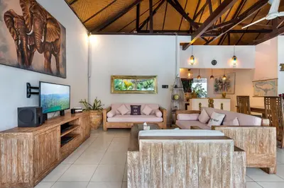 a living room with a couch and a tv at Villa Jasmin Seminyak in Seminyak