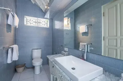 a bathroom with a sink and a toilet and a mirror at 2 BedRoom Villa Hideaways Seminyak in Seminyak