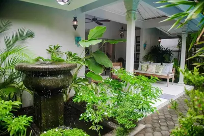 a garden with a fountain in front of a house at 2 BedRoom Villa Hideaways Seminyak in Seminyak