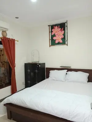 a bedroom with a bed and a painting on the wall at Nyoman bali house villa in Seminyak