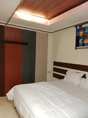 a bedroom with a white bed and a wooden ceiling at Nyoman bali house villa in Seminyak