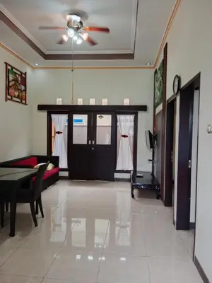 a living room with a couch and a ceiling fan at Nyoman bali house villa in Seminyak